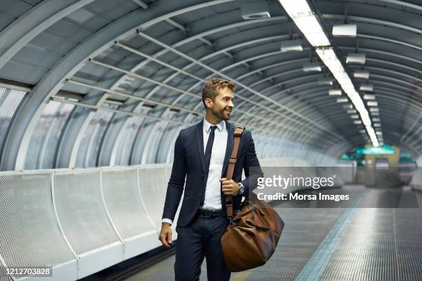 empresário sorridente olhando para longe na estação de metrô - metro - fotografias e filmes do acervo