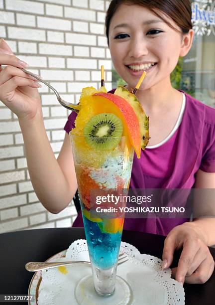 Woman eats a 34 cm tall fruit sundae, called "today's high temperature parfait" at a cafe in Tokyo on August 17, 2011. The hotel's restaurant serves...