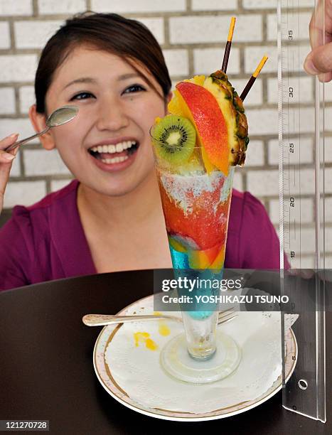 Woman eats a 34 cm tall fruit sundae, called "today's high temperature parfait" at a cafe in Tokyo on August 17, 2011. The hotel's restaurant serves...