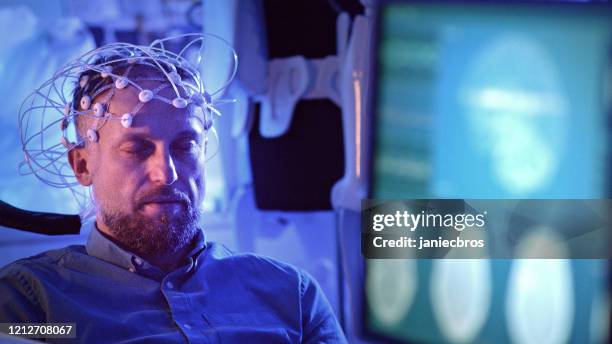 mann trägt brainwave scanning headset. - eeg electrode cap stock-fotos und bilder