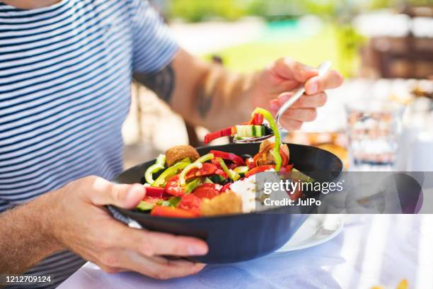 mensen die griekse salade eten - mediterraanse gerechten stockfoto's en -beelden