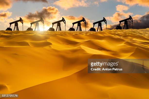 oil pump in the desert at sunset. world oil industry - pump jack stock pictures, royalty-free photos & images