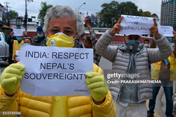 Human rights activists hold placards during a protest against India's newly inaugurated link road to the Chinese border, near Indian embassy in...