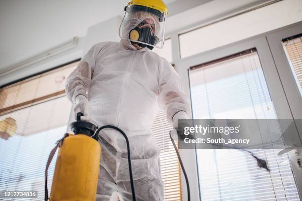 one man in protective suit disinfecting the home , and indoors space - roupa protetora imagens e fotografias de stock