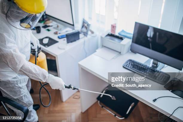 en man i skyddsdräkt desinficera kontorsarbete utrymme - office cleaning bildbanksfoton och bilder