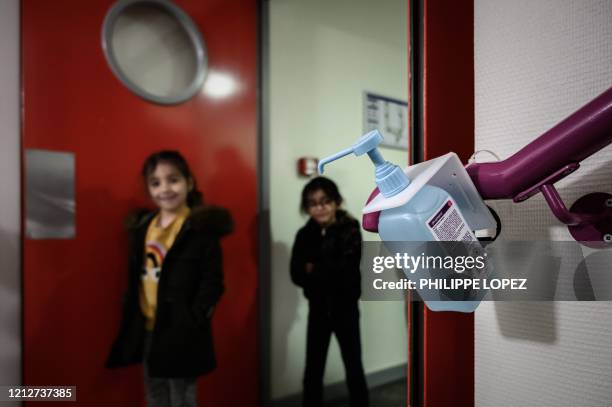 Pupils walk past an hydroalcoholic gel dispenser at the private Catholic school Institut Sainte-Genevieve in Paris, on May 12 as the schools in...