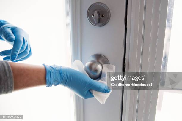 manos con guante limpiando pomo de la puerta. - disinfection fotografías e imágenes de stock