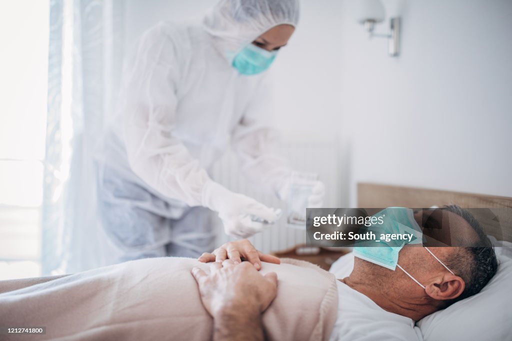 Senior man lying in hospital bed because of coronavirus infection