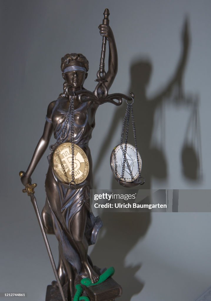 Digital currencies. Symbol photo on the subject Bitcoin, Ethereum. Justita with Bitcoin and Ethereum coins (physical).