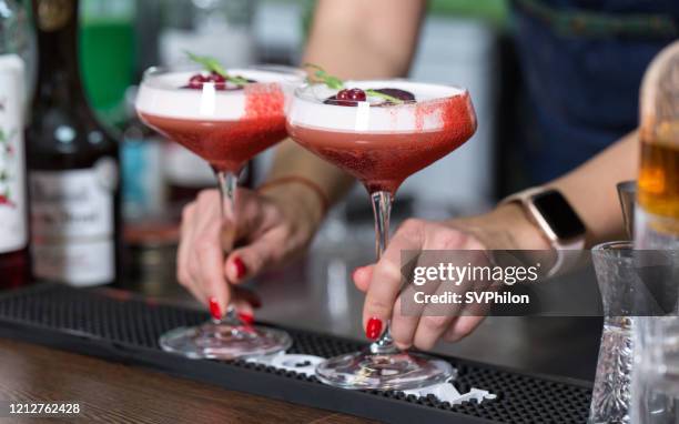 a professional bartender presents a made cocktail. - cranberries stock pictures, royalty-free photos & images