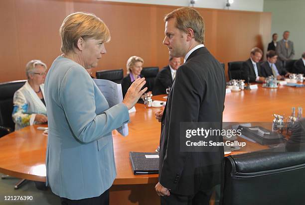 German Chancellor Angela Merkel and Health Minister Daniel Bahr chat prior to the weekly German government cabinet meeting on August 17, 2011 in...