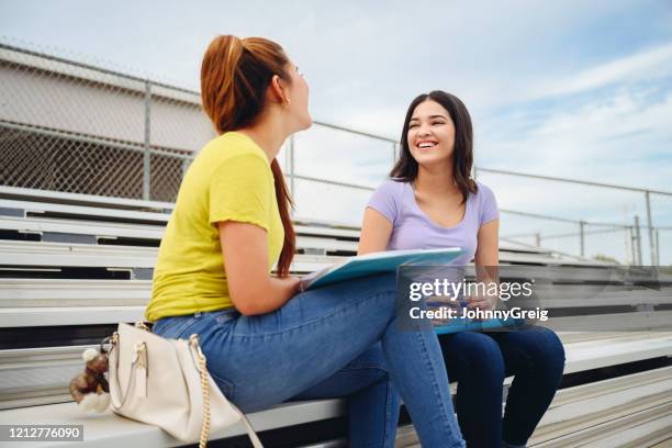 hispanic students working on homework in outdoor bleachers - girl who stands stock pictures, royalty-free photos & images