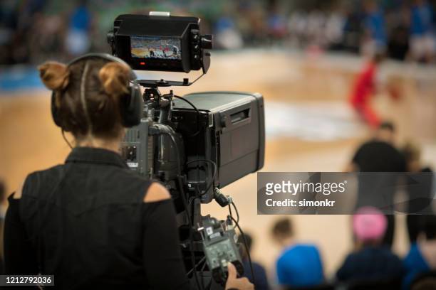 weibliche kamerafrau schießen basketball-spiel - camera operator stock-fotos und bilder