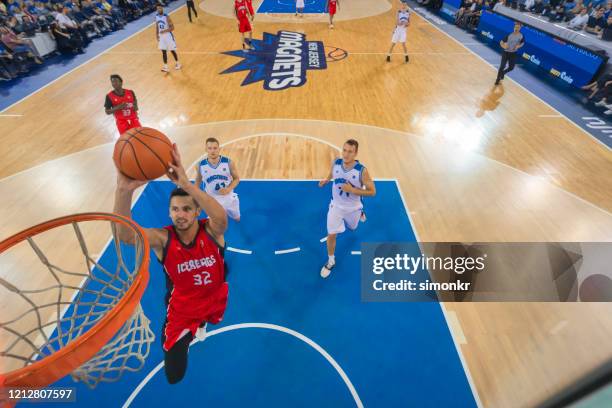 de speler slam dunking basketbal van het basketbal - basketball competition stockfoto's en -beelden