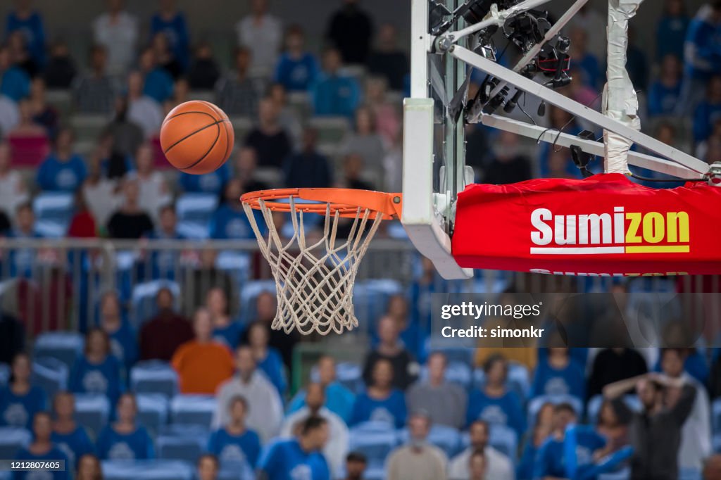 Basketball reaching to hoop