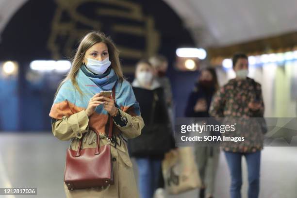 Woman at the subway wearing a face mask as precaution during the covid 19 pandemic. Since 12 May in Saint-Petersburg wearing face masks and gloves to...