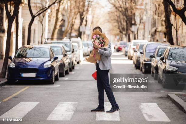 young man carrying flower bouquet - bunch imagens e fotografias de stock