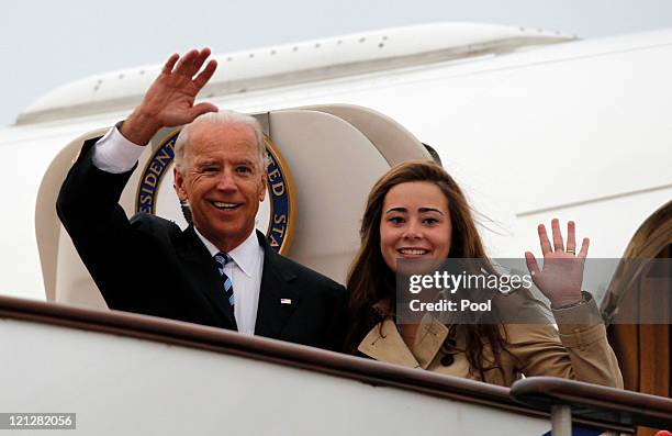 Vice President Joe Biden waves with his granddaughter Naomi Biden as they walk out from Air Force Two upon arrival at the Beijing Capital...