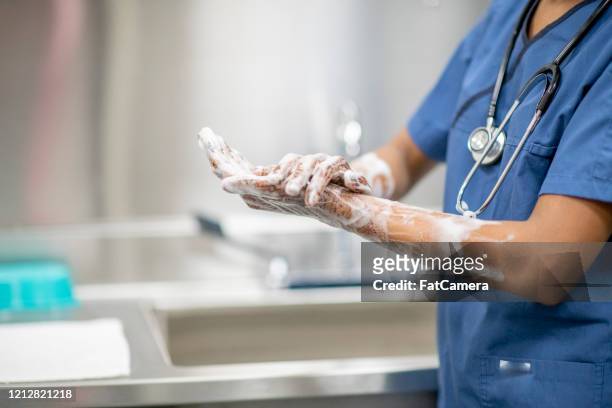 lavado de manos del personal médico vestido con la foto de archivo de medical scrubs - infectious disease fotografías e imágenes de stock