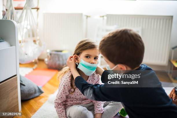 kinder tragen verschmutzungsmasken zu hause - atemschutzmasken stock-fotos und bilder