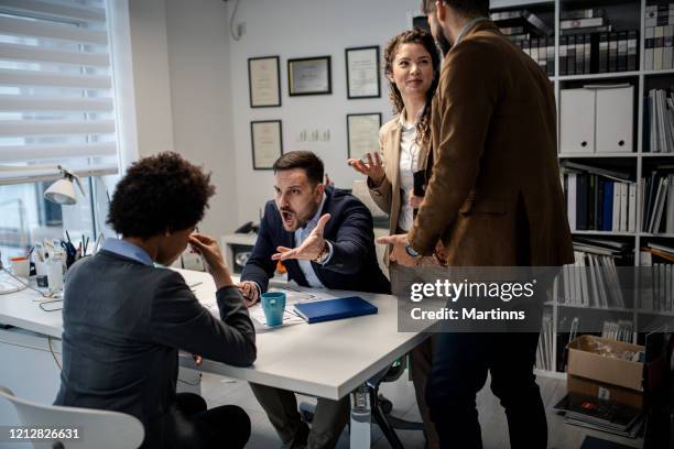 boze manager die zijn ondergeschikte bij het bureau uitscheldt - harassment work stockfoto's en -beelden