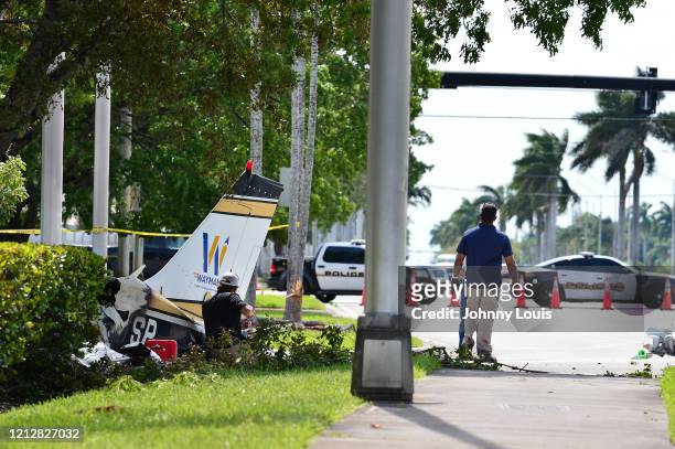 Investigator look over the crash site of a Piper PA-34 plane on May 12, 2020 in Miramar, Florida. The plane was seen flying low over an intersection...