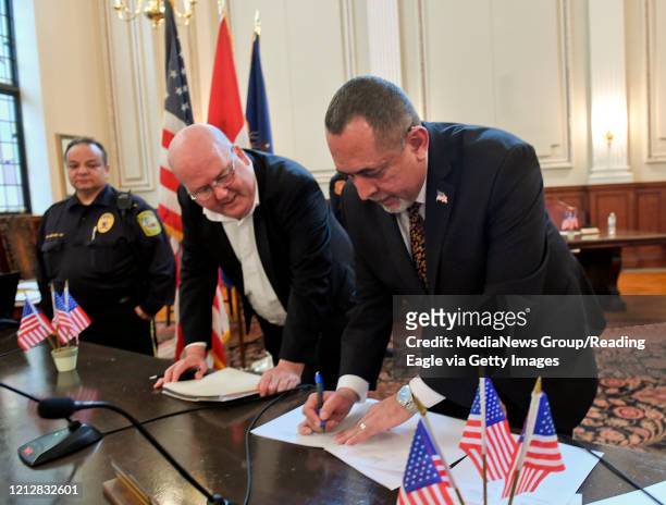 Reading, PA Reading City Council President Jeffrey S. Waltman Sr., left, watches as Reading Mayor Eddie Moran signs the declaration of Disaster...