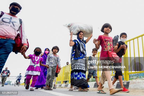 Girl with an artificial leg walks with her family of migrant workers towards their respective hometown states during a government-imposed nationwide...