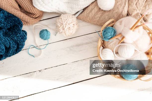 vintage knitting needles, scissors and yarn inside old wire basket on wooden stool, still life photo with soft focus - aiguille à tricoter photos et images de collection