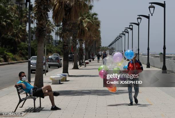 Man sells ballons at Beirut seaside corniche on May 2020. - Lebanon's cabinet has announced yesterday a four-day nationwide lockdown from wednesday...