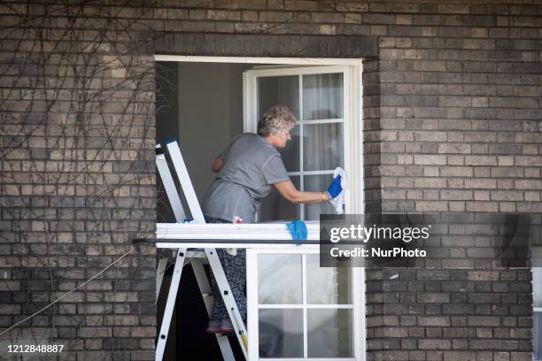 Woman cleans windows in a monastery in Warsaw, Poland on April 20, 2020.