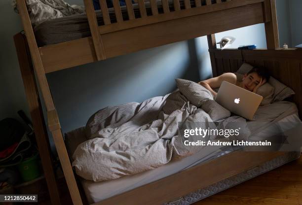 Senior at Brooklyn Tech high school lies in bed at home in the middle of the afternoon on a weekday after the New York City public school system...
