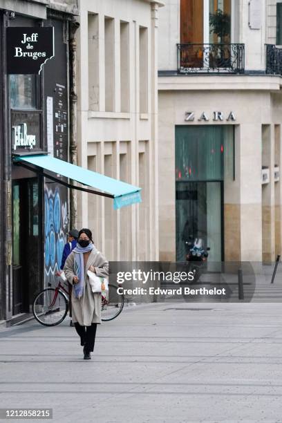 Passerby wears a protective face mask, near the Zara store, at Avenue des Champs Elysees, in the 8th quarter of Paris, as the city imposes emergency...