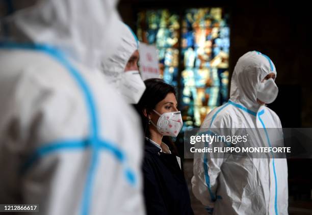 Rome mayor Virginia Raggi , wearing a face mask, stands with members of the Italian Army and of Rome's street cleaning task force personnel during...