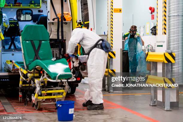 Healthcare worker cleans and disinfects an ambulance after dropping a patient at the Intensive Care Unit at Danderyd Hospital near Stockholm on May...