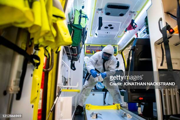 Healthcare worker cleans and disinfects an ambulance after dropping a patient at the Intensive Care Unit at Danderyd Hospital near Stockholm on May...