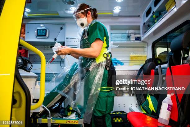 Paramedic cleans and disinfects an ambulance after dropping a patient at the Intensive Care Unit at Danderyd Hospital near Stockholm on May 13 during...