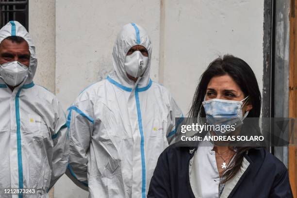 Rome mayor Virginia Raggi, wearing a face mask and employees of Rome's Municipal Environment Company , wearing protective overall and mask, attend...