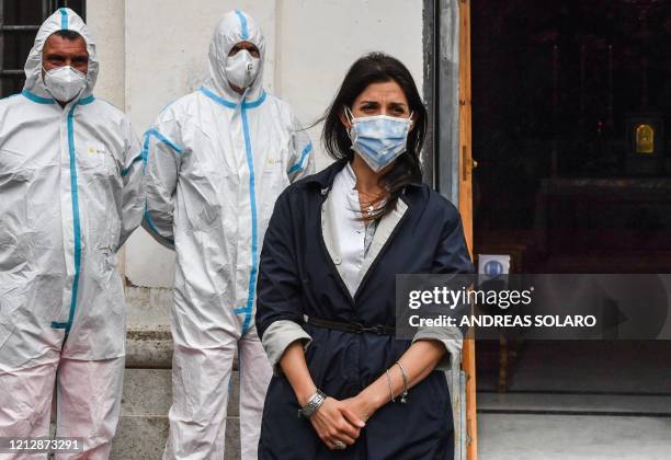 Rome mayor Virginia Raggi, wearing a face mask and employees of Rome's Municipal Environment Company , wearing protective overall and mask, attend...