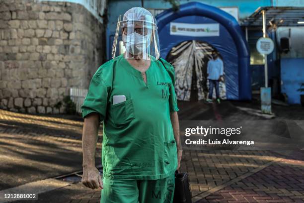 Orthopedist Fernando Medeiros wearing a face mask and shield returns to work in the Dr. Armando Gomes de Sa Couto ER, after recovering from the...