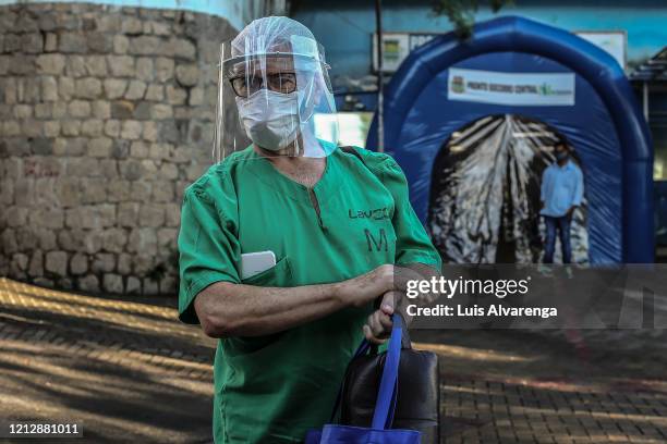 Orthopedist Fernando Medeiros wearing a face mask and shield returns to work in the Dr. Armando Gomes de Sa Couto ER, after recovering from the...