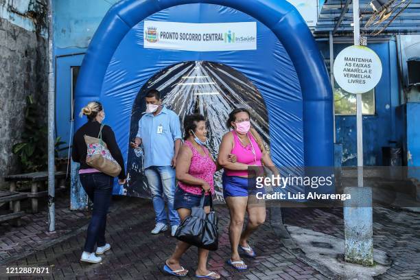 People walk in front a disinfection tunnel at Dr. Armando Gomes de Sá Couto ER during the coronavirus pandemic on May 13, 2020 in São Gonçalo,...