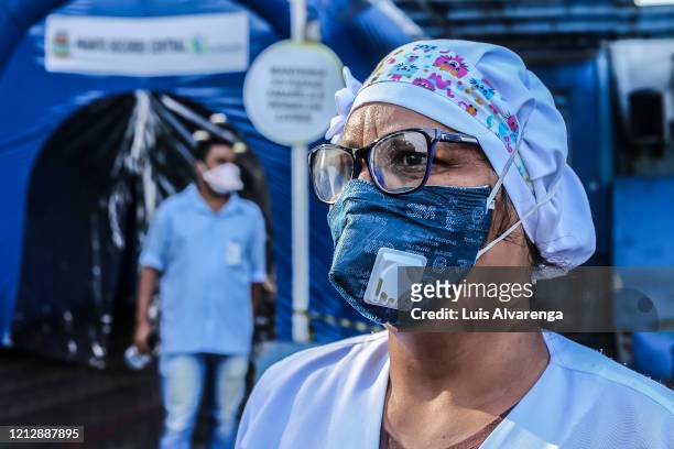 Health professional wearing a face mask looks on in front a disinfection tunnel at Dr. Armando Gomes de Sá Couto ER during the coronavirus pandemic...