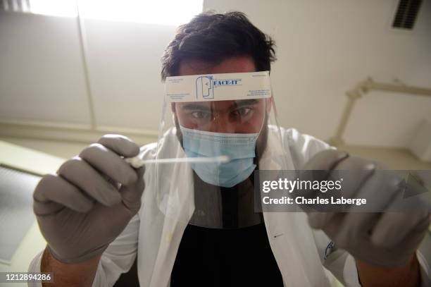 Closeup portrait of Kansas City Chiefs offensive guard Laurent Duvernay-Tardif holding swab during photo shoot at longterm care facility....