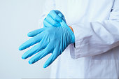 doctor man putting on surgical gloves