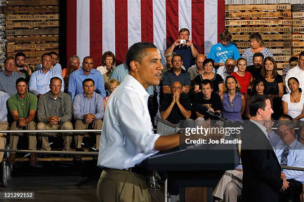 People listen as President Barack Obama speaks at a town hall-style meeting at Wyffels Hybrids Inc. On August 17, 2011 in Atkinson, Illinois....