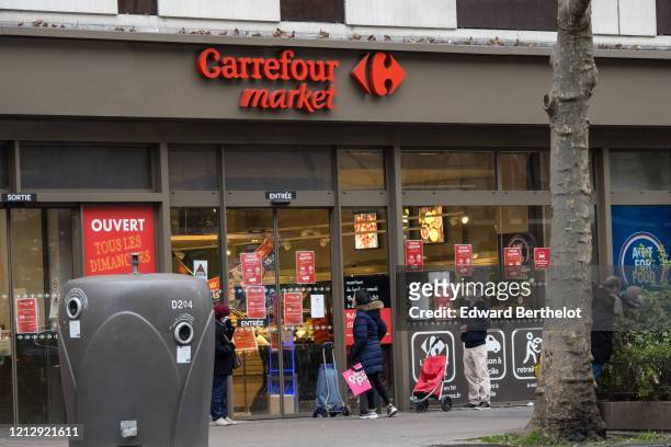 General view of people waiting in queue, in front of a Carrefour Market store which regulates the admission of shoppers, while the city imposes...