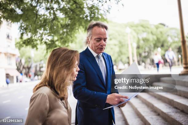 ceo en zijn secretaresse die aan het bureau lopen - city map stockfoto's en -beelden