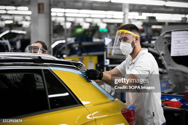 An employee wearing a protective mask as a precaution against Covid-19 work in the assembly line for the Volkswagen T-Roc at Autoeuropa's car...