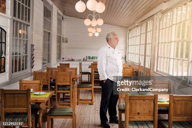 restaurant owner standing in his empty restaurant. - cerrado imagens e fotografias de stock